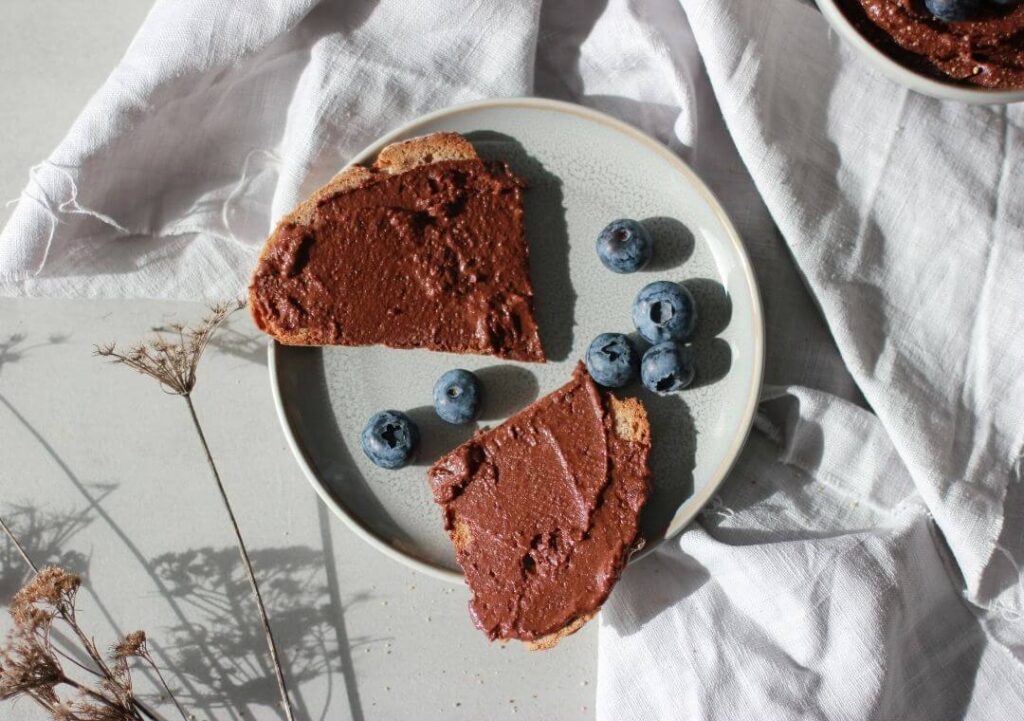 Teller mit Brot, bestrichen mit Schoko Hummus und Blaubeeren