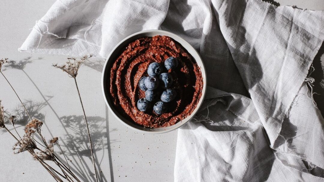 Schüssel mit veganer Schoko Hummus und Blaubeeren